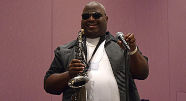Toney smiles as he prepares to play the saxaphone.