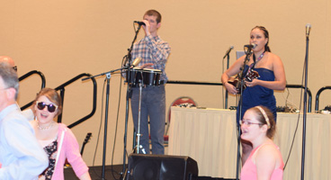 Precious and her bandmate sing to a dancing crowd.